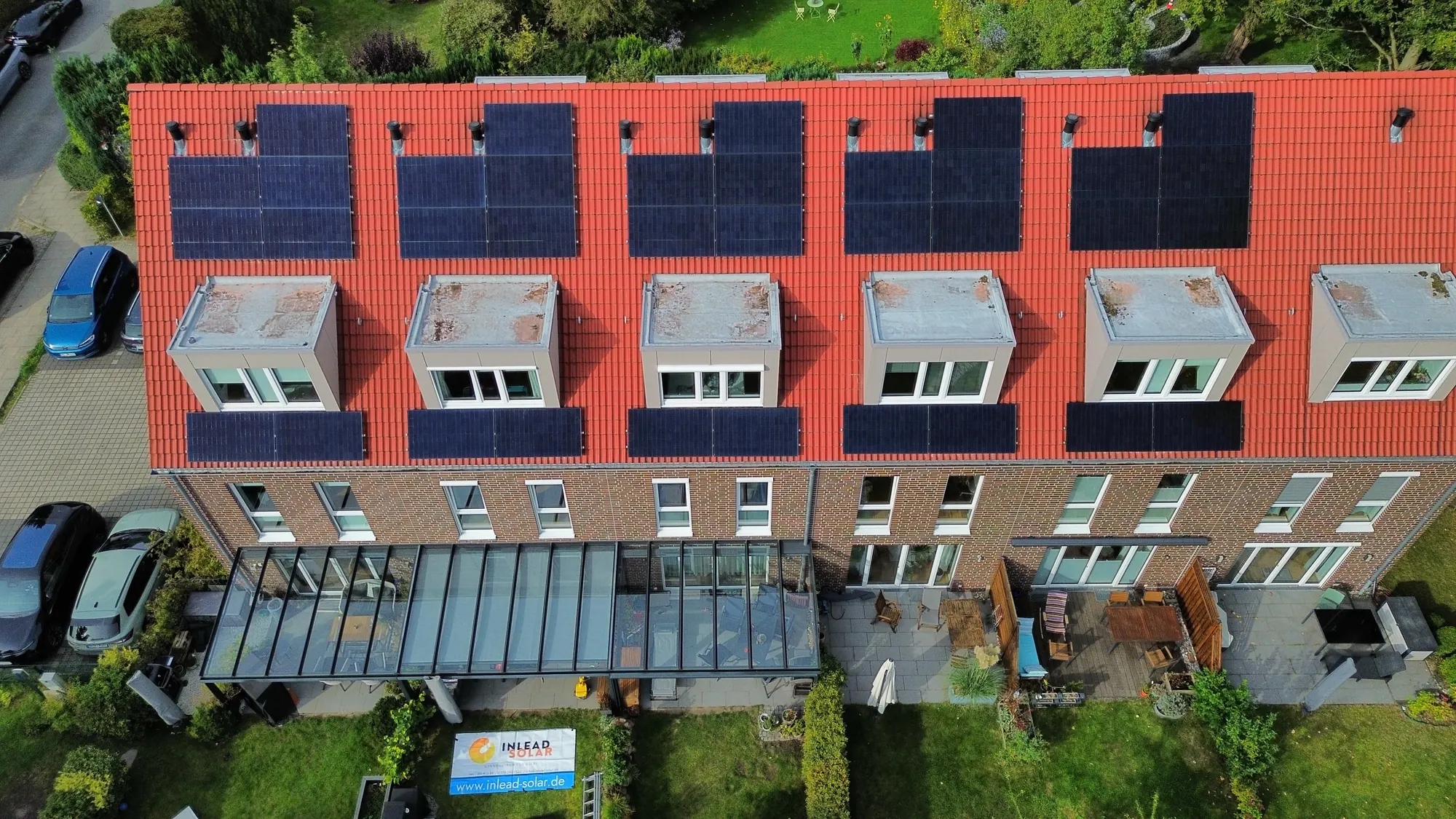 Reihenhausdächer mit einheitlich verlegten Solarmodulen, Drohnenansicht